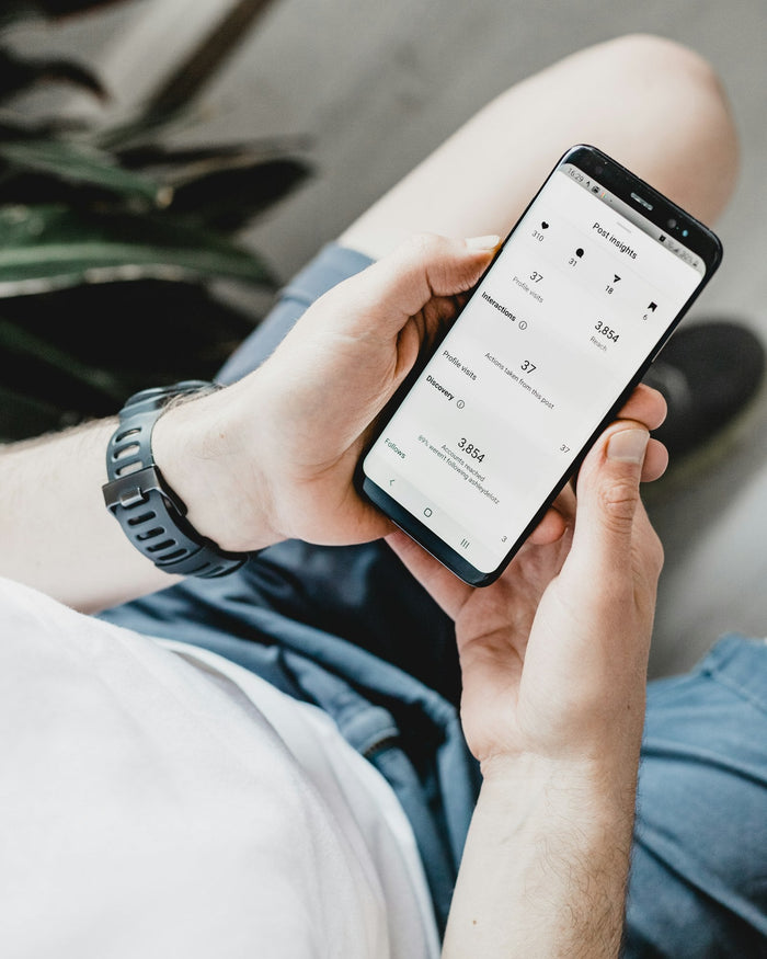 Person holding a smartphone to set up the Fitbit Air in the Google Health app