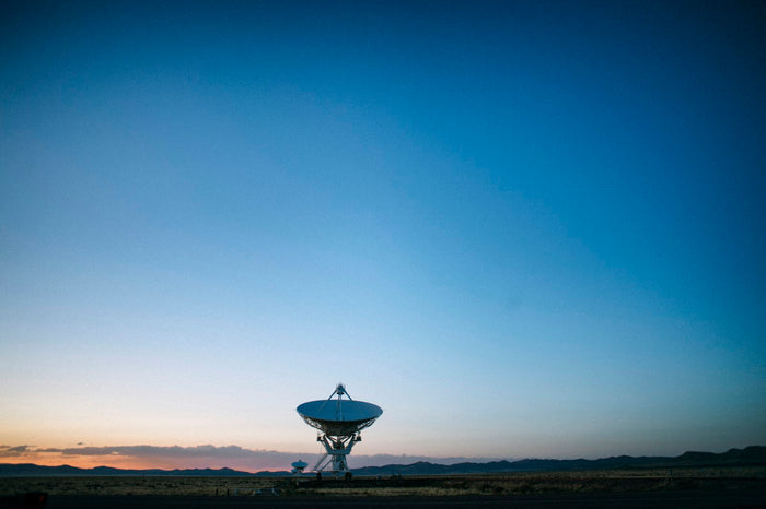 Satellite dish on dry open ground under a clear blue sky, Starlink troubleshooting in UAE heat