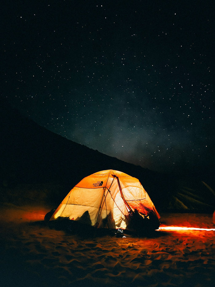 Tent lit up at night in the desert during a winter camping trip