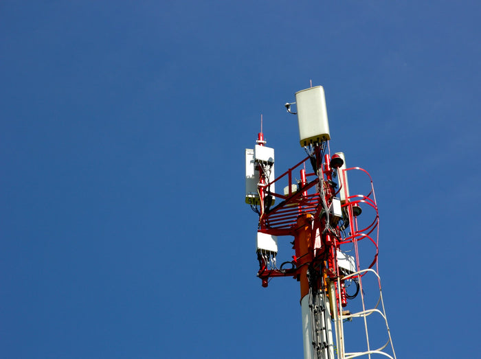 Mobile 5G tower against a blue sky, Starlink vs 5G home internet in the UAE
