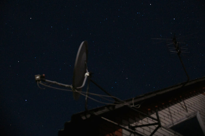 Satellite dish mounted on a rooftop with a clear view of the sky