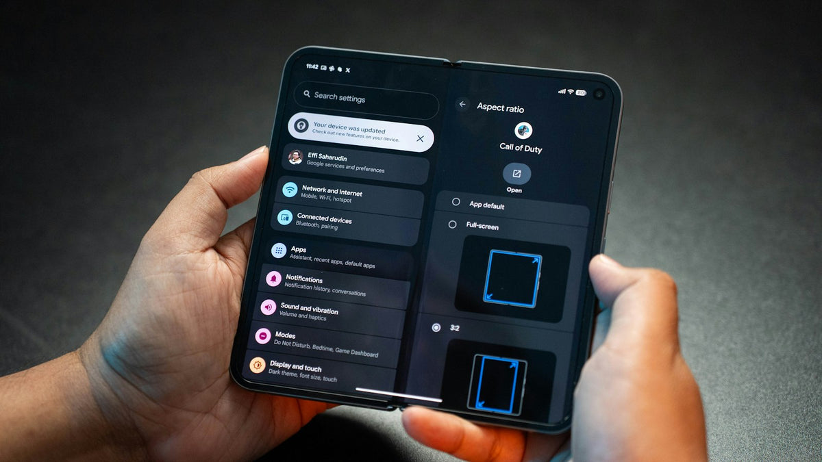 Hands holding a smartphone showing a settings menu, like managing a Starlink subscription in the app