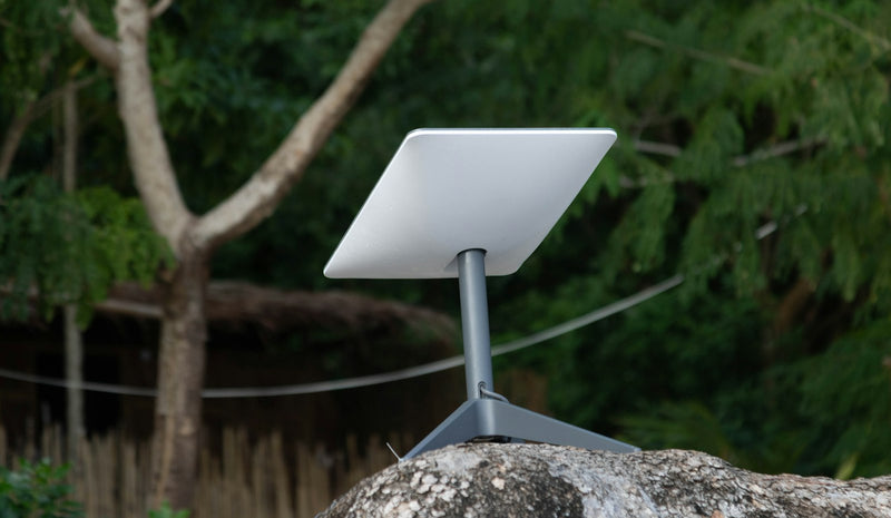 Starlink satellite dish set up on rocks by the sea